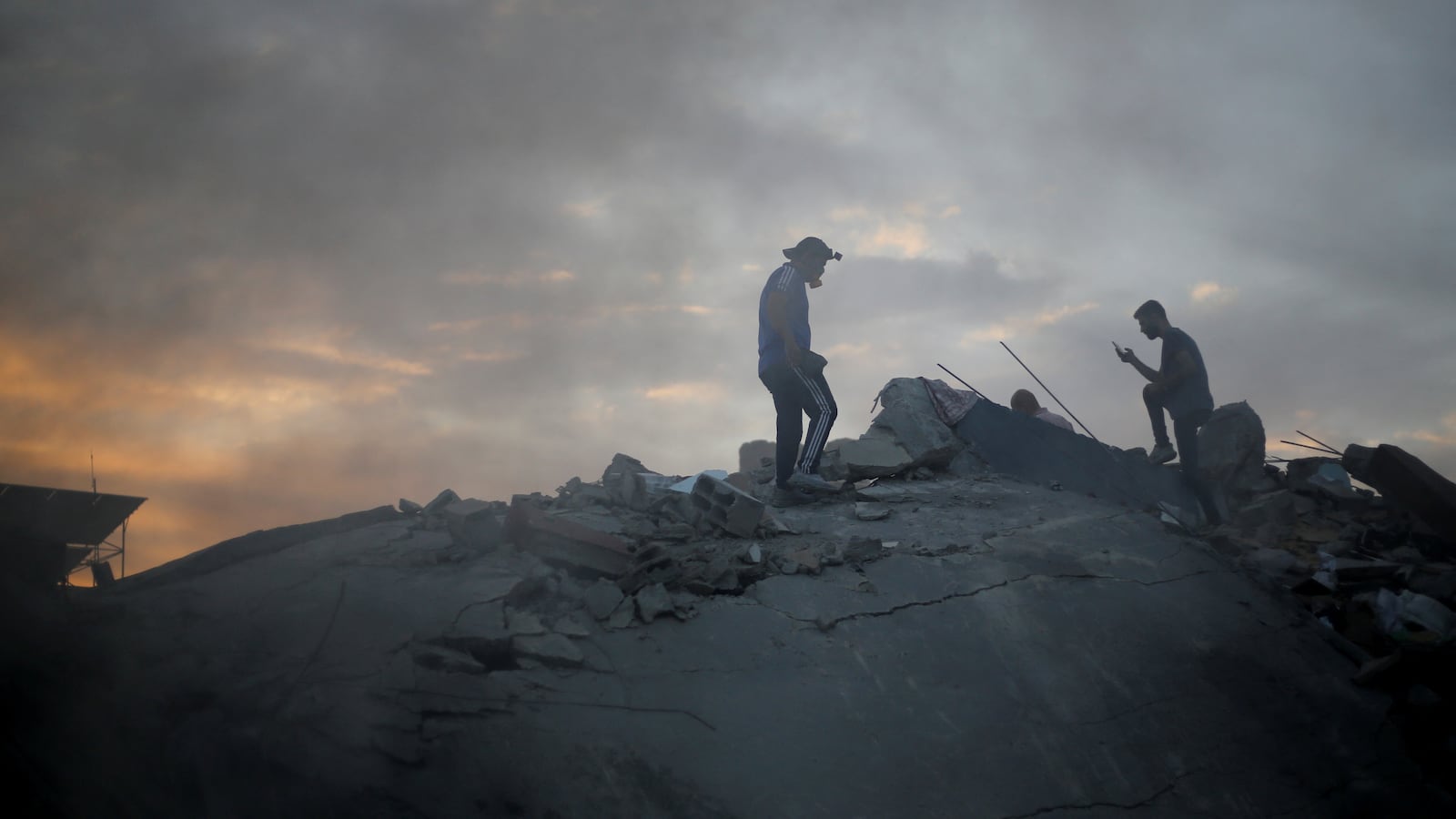 Palestinians search for casualties at the site of Israeli strikes on a residential building