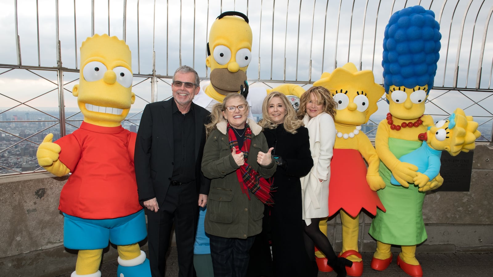 NEW YORK, NY - DECEMBER 17: (L-R) Bart Simpson, Mike Scully, Homer Simpson, Nancy Cartwright, Pamela Hayden, Stephanie Gillis, Lisa Simpson, Marge Simpson and Maggie Simpson visit The Empire State Building to celebrate the 30th anniversary of "The Simpsons" at The Empire State Building on December 17, 2018 in New York City. (Photo by Noam Galai/Getty Images)