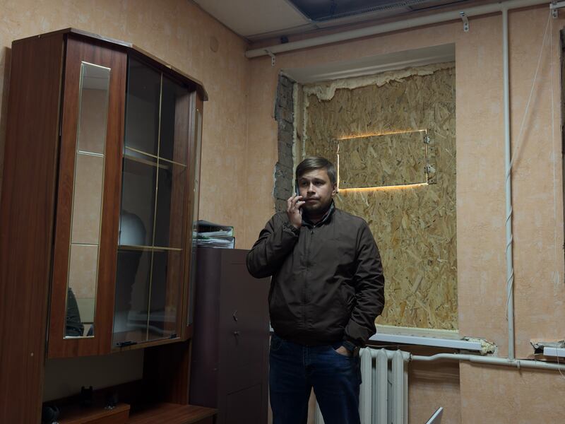 Mayor Vitaly Sadovii on the phone in his office in Zolochiv as air raid alarms begin.
