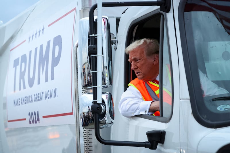 President Donald Trump sits inside garbage truck as he wears a high-vis vest, on tarmac at Green Bay Austin Straubel International Airport in Green Bay, Wisconsin, U.S., October 30, 2024.