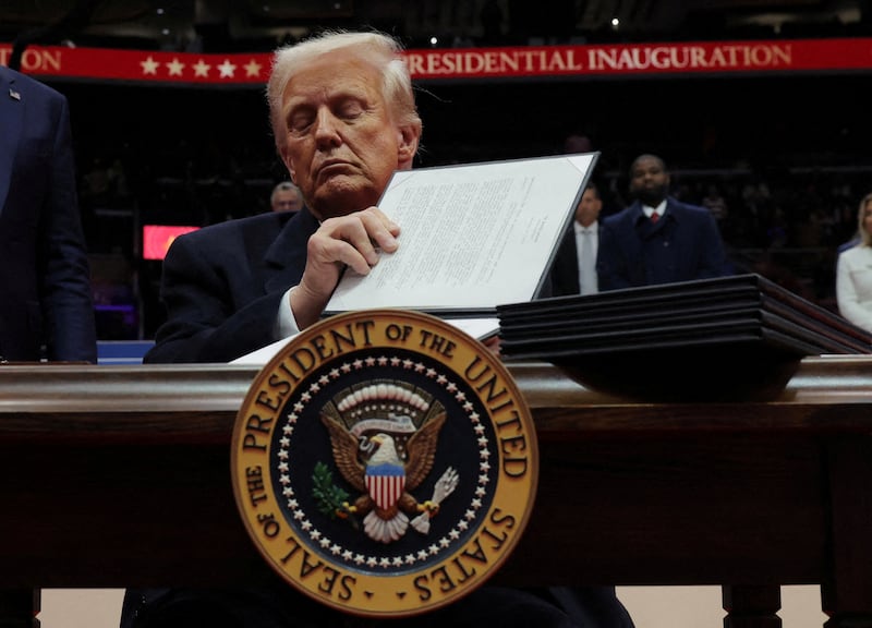 FILE PHOTO: U.S. President Donald Trump signs an executive order during the inaugural parade inside Capital One Arena on the inauguration day of his second presidential term, in Washington, U.S. January 20, 2025. REUTERS/Carlos Barria/File Photo