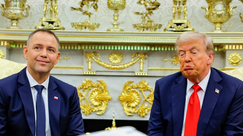 U.S. President Donald Trump reacts while sitting next to the President of Poland Karol Nawrocki during a meeting in the Oval Office at the White House