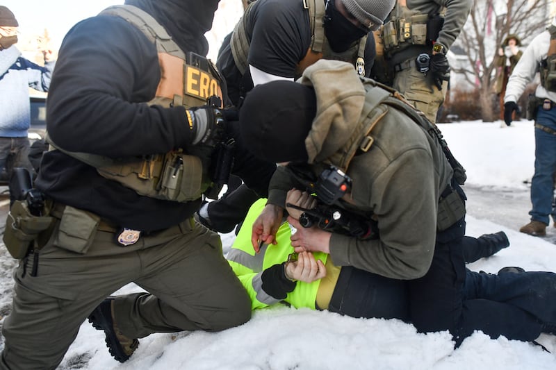 ICE and other federal officers detain a person during protests as ICE operates in a residential neighborhood in Minneapolis, Minnesota, on January 13, 2026.