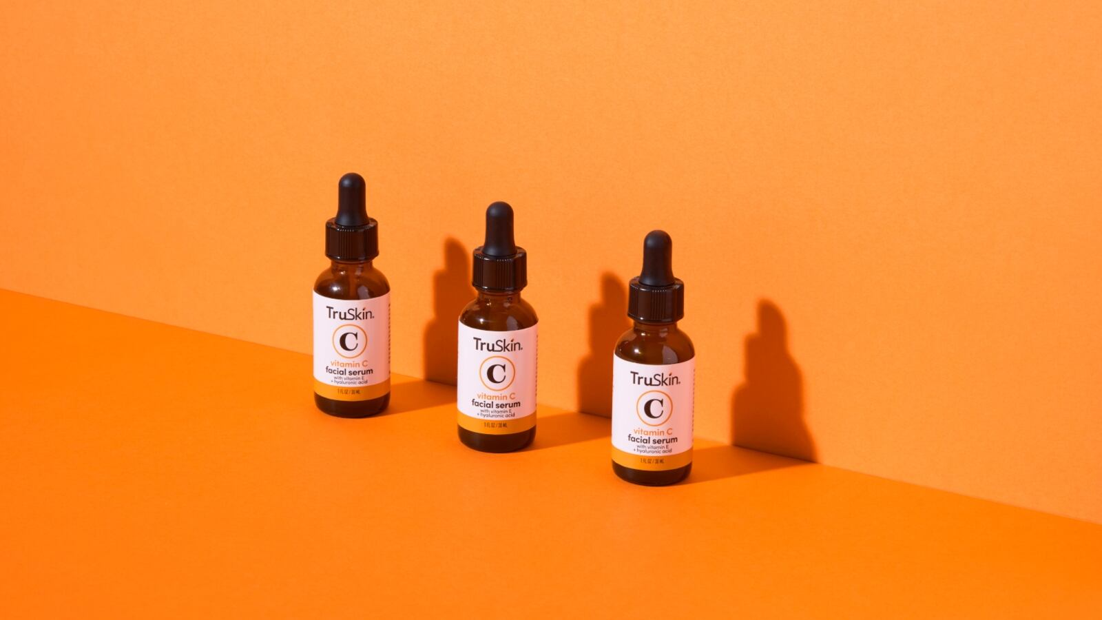 TruSkin Vitamin C skincare serums in front of an orange background