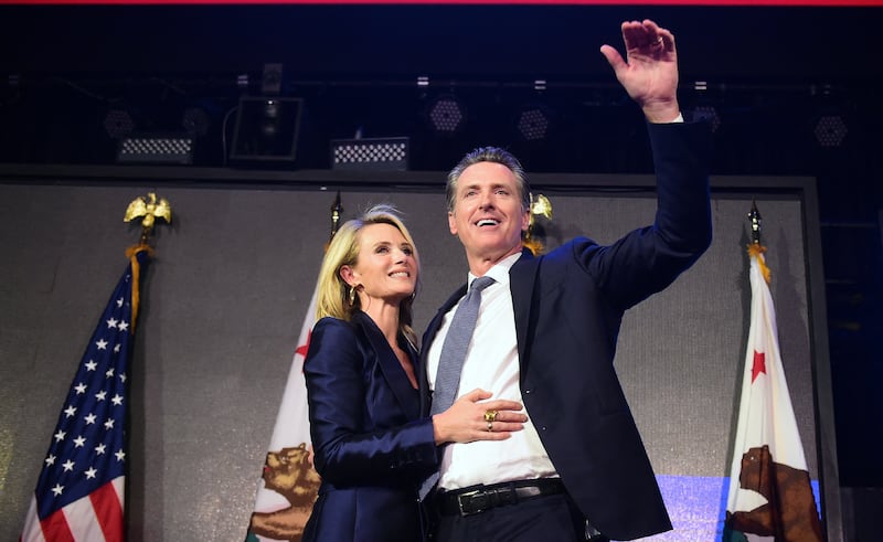 California's Democratic gubernatorial candidate Gavin Newsom gestures with his wife by his side at his election night watch party in Los Angeles, California on November 6, 2018. Gavin Newsom defeated his Republican opponent John Cox to become the next Governor of California.