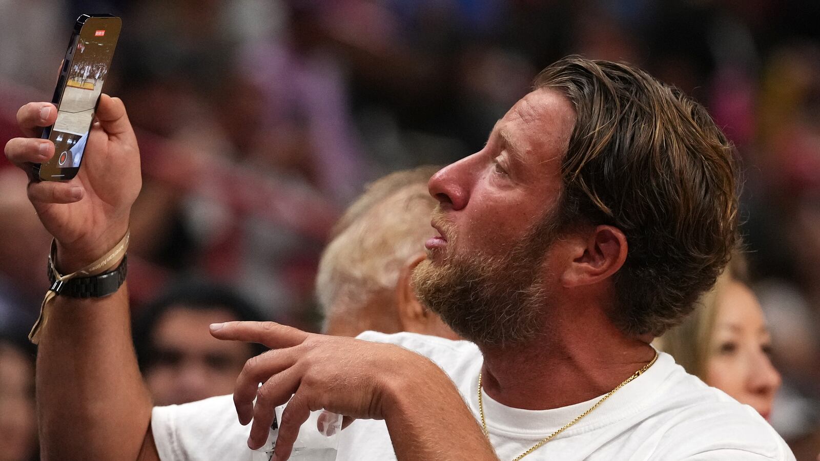 Dave Portnoy looks at his phone while sitting court-side during the first half between the Miami Heat and the Boston Celtics
