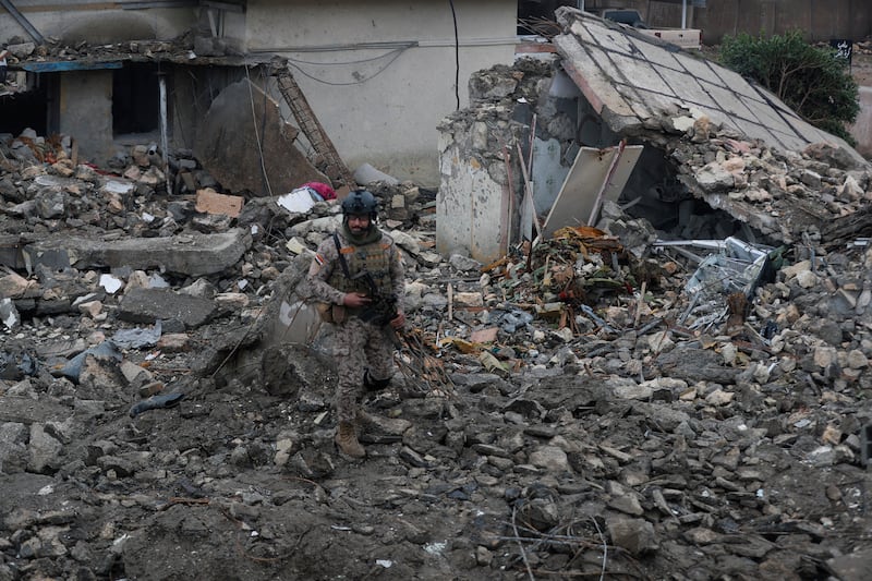 TOPSHOT - An Iraqi soldier stands guard at the site of a destroyed healthcare center in the Habbaniyah military base, which was targeted by in an airstrike killing seven security personnel and wounding 13 others, in Habbaniyah, west of Baghdad on March 26, 2026. Iraq announced on March 25 that it will file a complaint with the UN Security Council regarding the attacks targeting its territory since the start of the war, hours after seven soldiers were killed in an attack on their position in the west of the country. (Photo by AHMAD AL-RUBAYE / AFP via Getty Images)