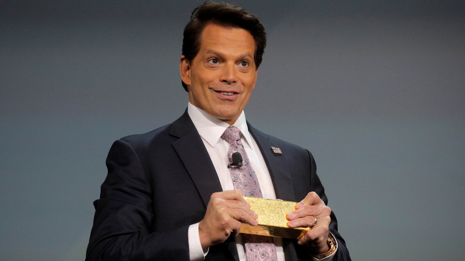 Anthony Scaramucci stands on stage holding note cards.