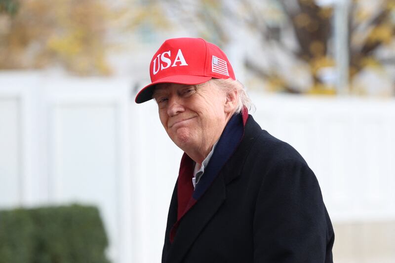 US President Donald Trump smiles as he walks from Marine One to the White House after landing on the South Lawn in Washington, DC, on November 22, 2025. Trump is returning to the White House after taking an aerial tour of The Courses at Joint Base Andrews, Maryland. (Photo by Alex WROBLEWSKI / AFP via Getty Images)