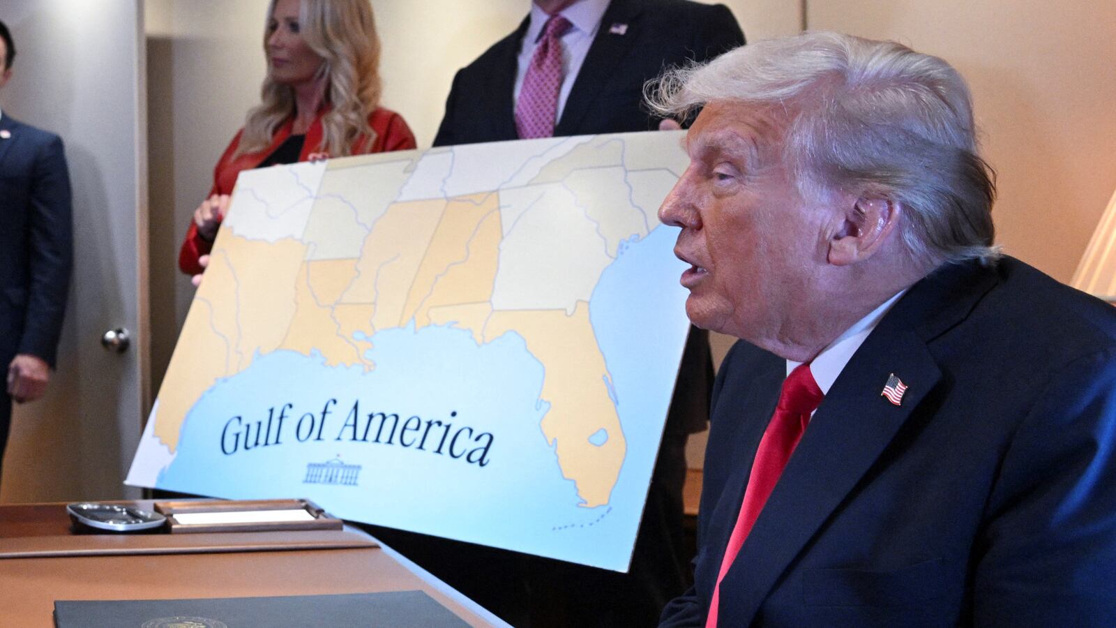 President Donald Trump speaks to reporters next to a map of the newly renamed Gulf of America on Air Force One.