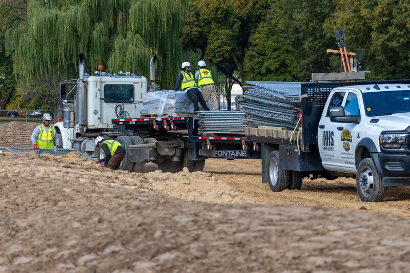 Trucks unload debris and soil from the demolition of the White House's East Wing at East Potomac Golf Course.
