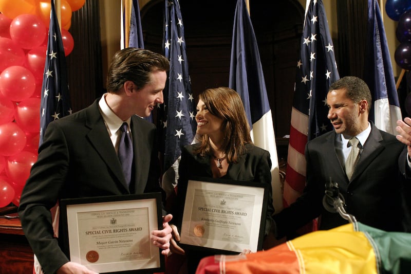 NEW YORK - JUNE 24: (L-R) Gavin Newsom, Mayor of San Francisco, wife Kimberly Newsom, and Senator David A. Paterson celebrate after the Newsoms won a Special Civil Rights Award during the 2004 Pride Awards Ceremony at City Hall, June 24, 2004 in New York City. (Photo by Andrew Kent/Getty Images)