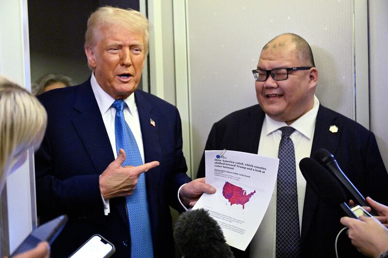 US President Donald Trump speaks with journalist, alongside White House Communications Director Steven Cheung (R), on board Air Force One on route from Miami, Florida, to the White House in Washington, DC on February 19, 2025. (Photo by ROBERTO SCHMIDT / AFP) (Photo by ROBERTO SCHMIDT/AFP via Getty Images)