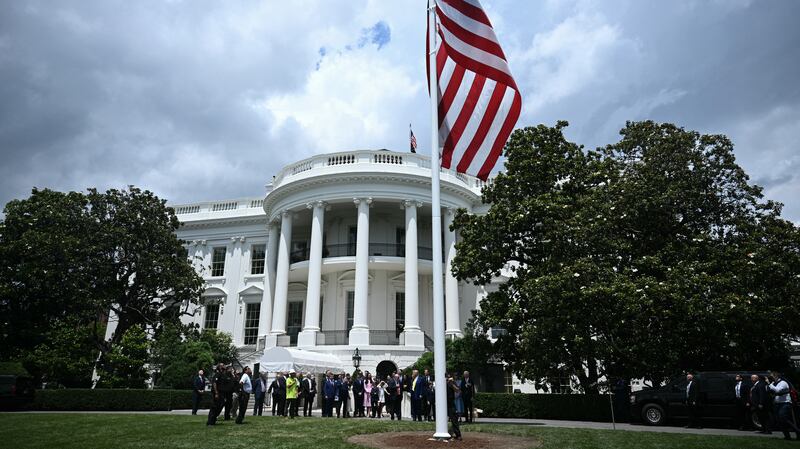 Trump looks on as a U.S. flag is raised on a newly installed flagpole on the South Lawn of the White House.