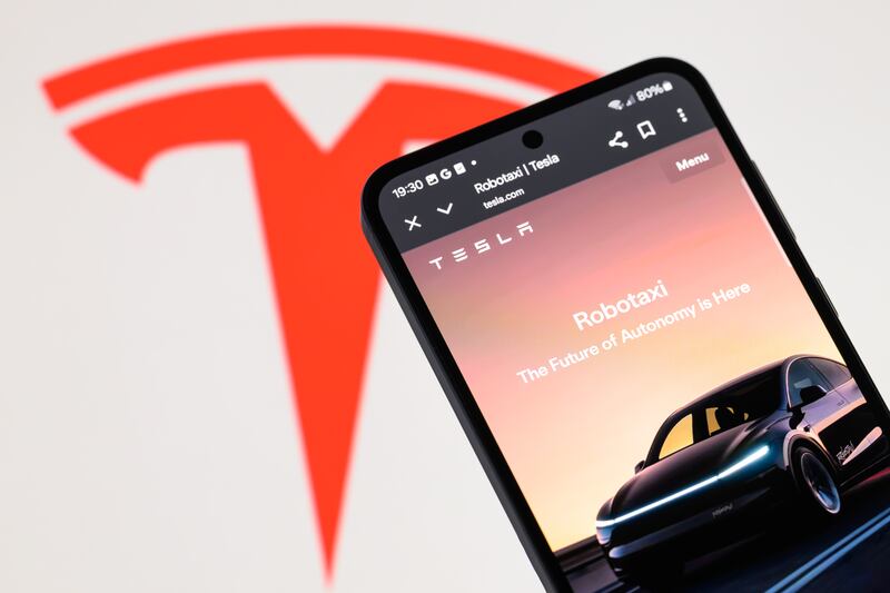 The Tesla Robotaxi home page is displayed on a mobile phone