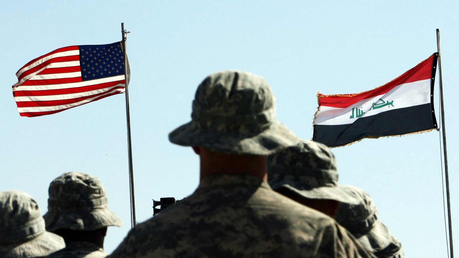 US troops stand to attention in front of American and Iraqi (R) flags during a handover ceremony near the northern Iraqi town of Hawija where the US military formally transferred Contingency Operating Location McHenry to Iraqi security forces on May 15, 2011. COL McHenry, just outside of Hawija and north of Baghdad in the disputed ethnically-mixed province of Kirkuk, was one of a handful of bases the US military maintained in Kirkuk and is considered the oldest American base in Iraq, having been established shortly after the 2003 invasion that ousted Saddam Hussein. AFP PHOTO / ALI AL-SAADI (Photo by ALI AL-SAADI / AFP) (Photo by ALI AL-SAADI/AFP via Getty Images)