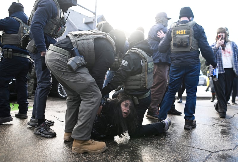 MINNEAPOLIS, MINNESOTA - JANUARY 13: ICE agents detain a woman after pulling her from a car before on January 13, 2026 in Minneapolis, Minnesota. The Trump administration has deployed over 2,400 Department of Homeland Security agents to the state of Minnesota in a push to apprehend undocumented immigrants. (Photo by Stephen Maturen/Getty Images)