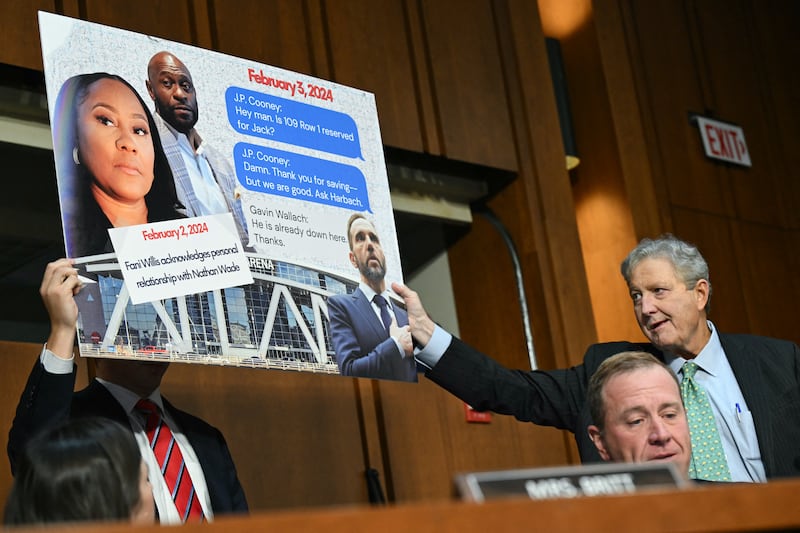 Sen. Eric Schmitt displayed a sign accusing former Special Counsel Jack Smith of meeting with Fulton County, Georgia, District Attorney Fani Willis during a hearing before the Senate Judiciary Committee in the Hart Senate Office Building on September 29, 2026, but the references in the text messages were not about attending an Atlanta Hawks game but an Iowa Hawkeyes game in Maryland.