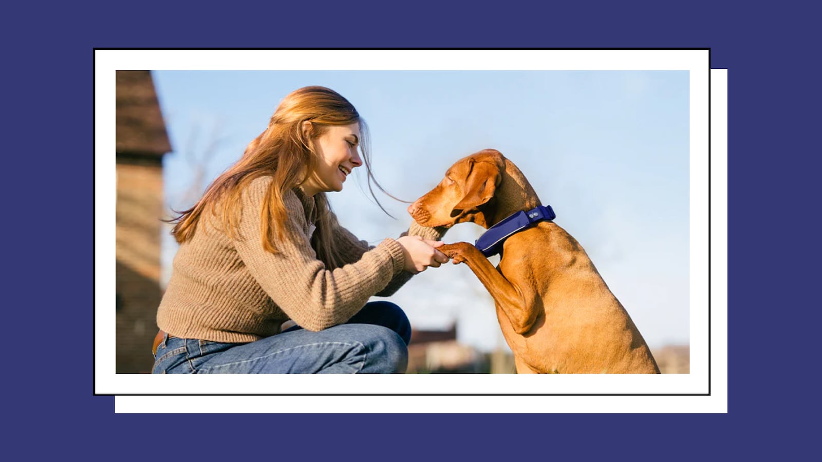 A blonde woman holding her dog's paws.