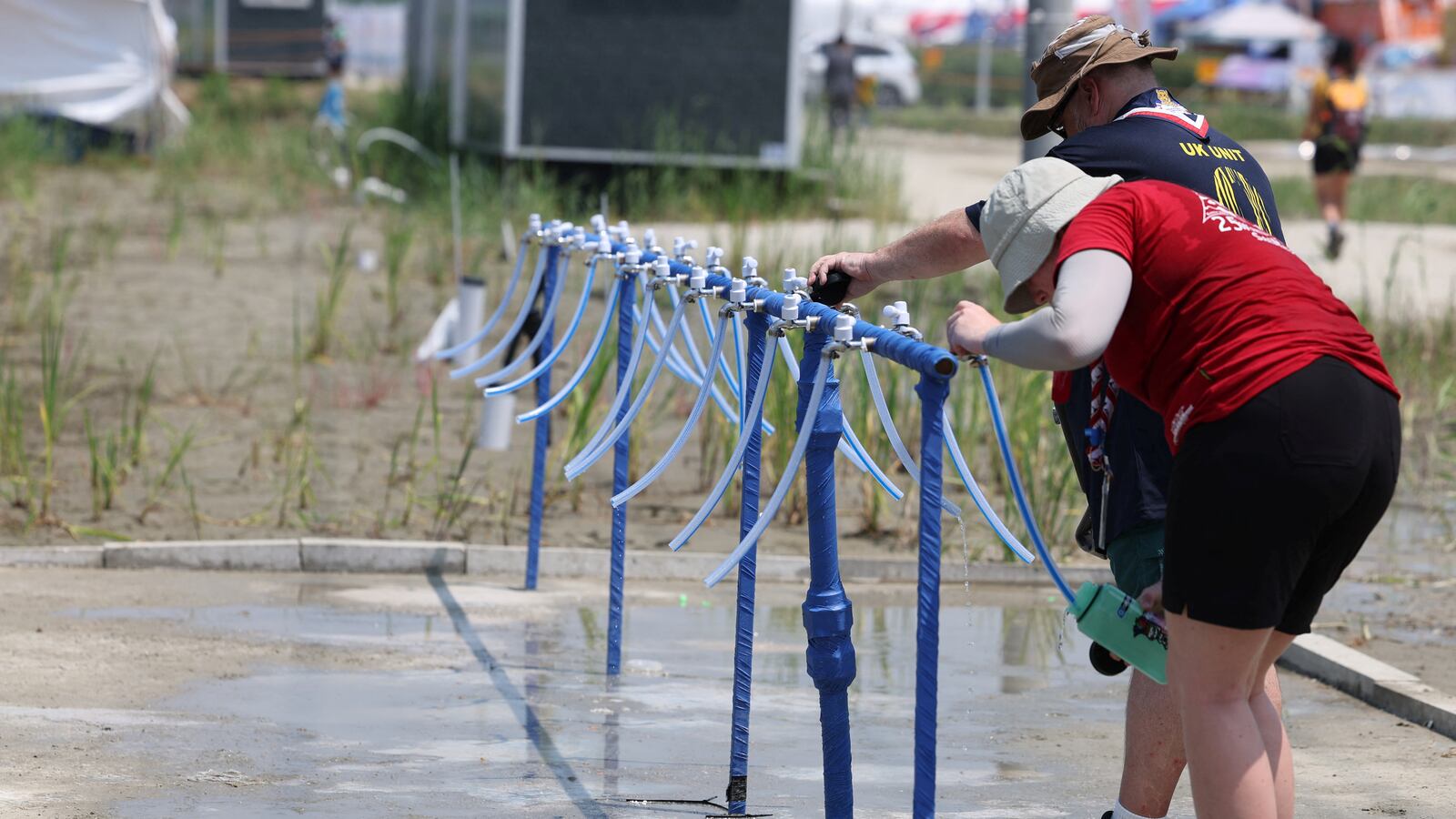 Participants for the 25th World Scout Jamboree fill water bottles at a water supply zone of a camping site in Buan, South Korea, August 2, 2023.
