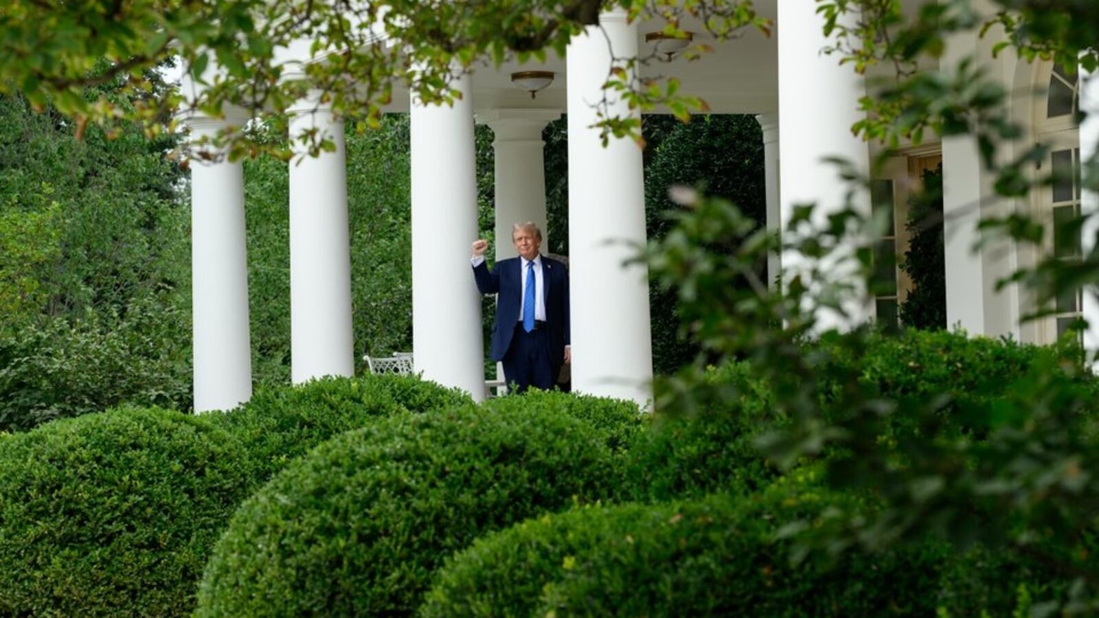 President Donald Trump tests the speakers of the newly renovated Rose Garden.