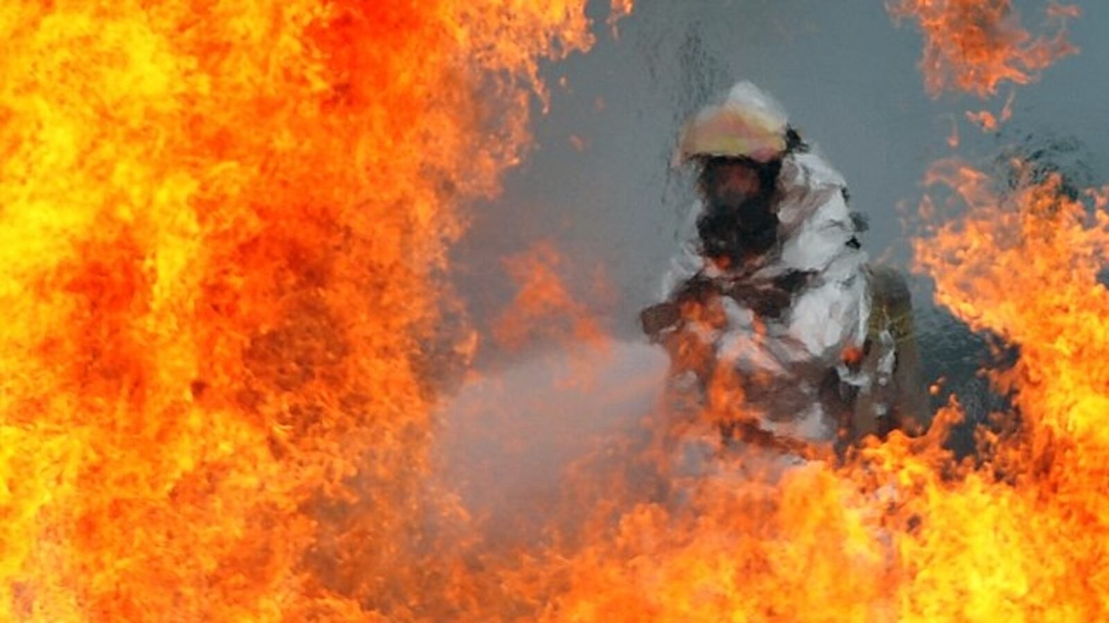 A U.S. Air Force firefighter sprays water at the fire of a simulated C-130 Hercules plane crash during operational readiness exercise Beverly Midnight 12-03 at Osan Air Base, Republic of Korea, on July 23, 2012.