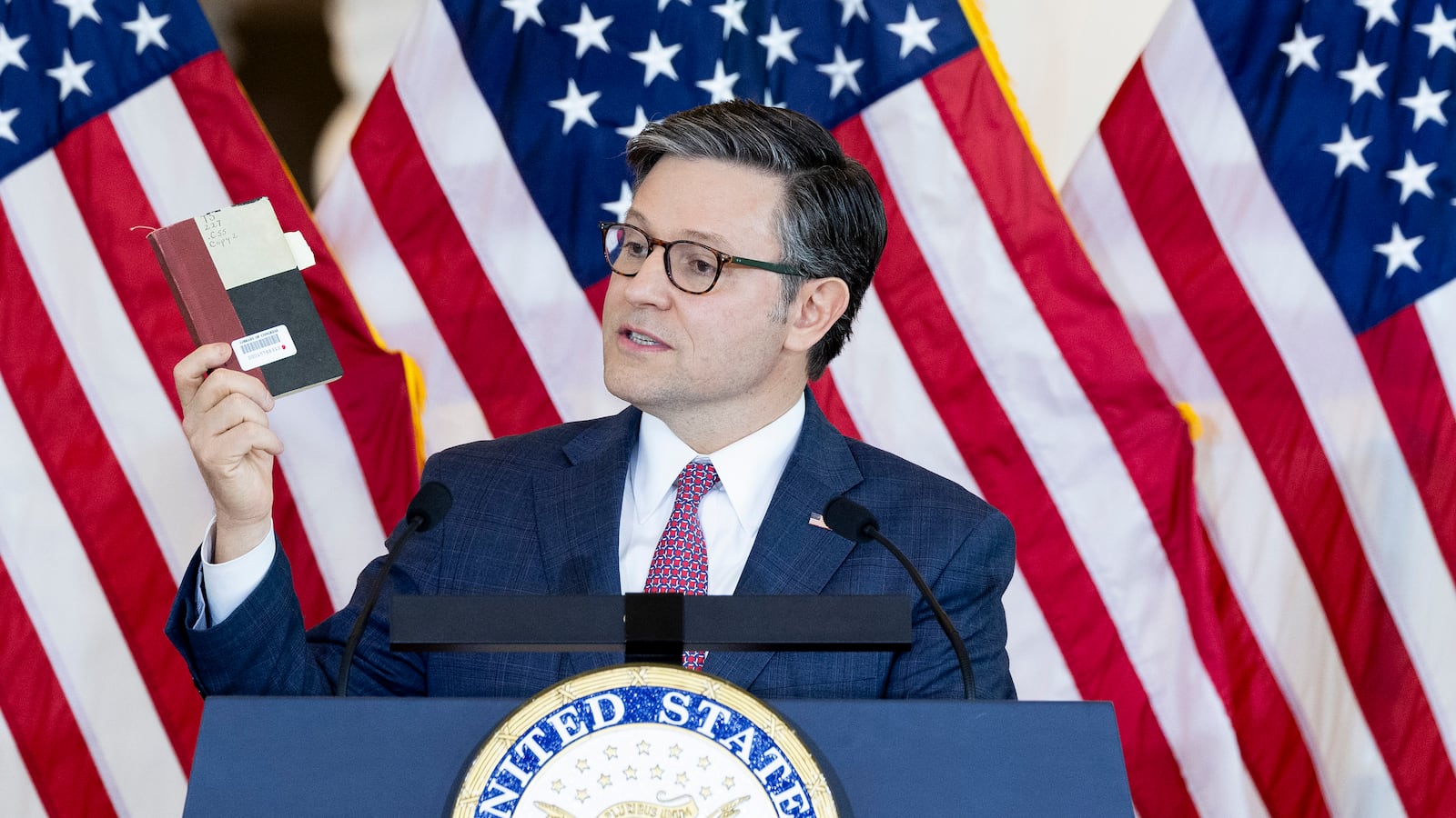 U.S. Speaker of The House Mike Johnson (R-LA) speaks during a Congressional Gold Medal Ceremony in front of U.S. flags.
