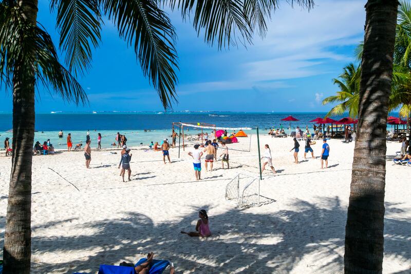 A photo of people playing volleyball on the beach in Cancun.