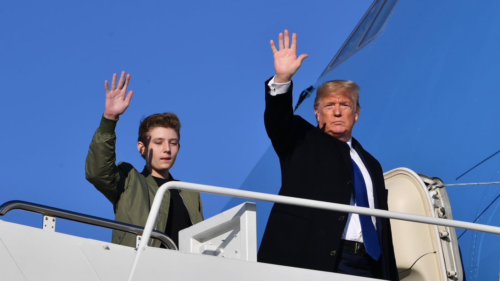 US President Donald Trump and son Barron Trump wave while making their way to board Air Force One at Andrews Airforce Base, Maryland on January 17, 2020.