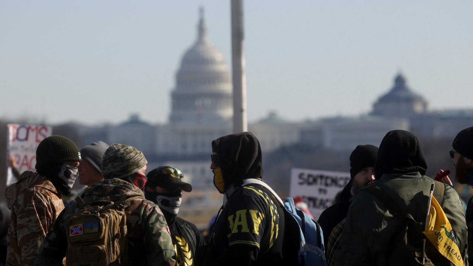A group of people, some of whom are dressed in colors and symbols associated with the group Proud Boys, which has been connected to the white supremacist ideology, gather with other protesters ahead of the march in opposition to coronavirus mandates.