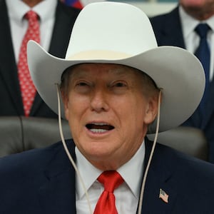 TOPSHOT - US President Donald Trump wears a cowboy hat during a bill signing ceremony with members of the 1980 US Olympic men's ice hockey team in the Oval Office of the White House in Washington, DC, on December 12, 2025. The legislation will award all of the players with Congressional Gold Medals to recognize the 45th anniversary of the US victory at the 1980 Winter Olympic Games. (Photo by Jim WATSON / AFP via Getty Images)