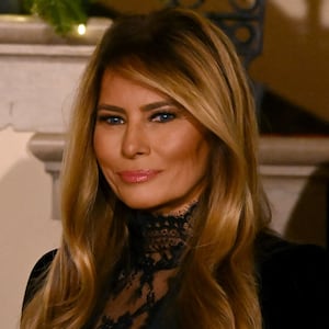 US First Lady Melania Trump looks on as President Donald Trump delivers remarks during the Congressional Ball in the Grand Foyer of the White House in Washington, DC, on December 11, 2025.