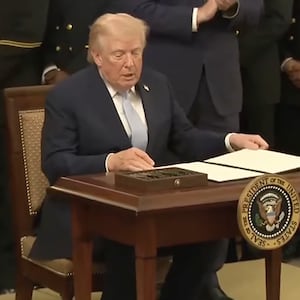 President Donald Trump sits to sign an executive order preserving the Army vs. Navy Game timeslot on March 20, 2026.