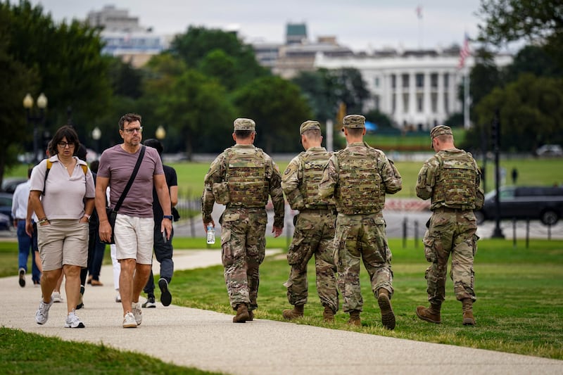 Members of the National Guard walk near the White House on the National Mall.