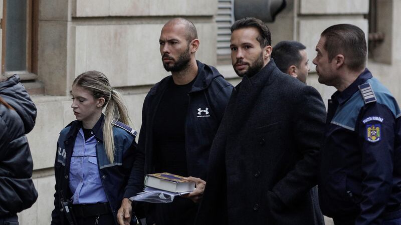 Andrew Tate and his brother Tristan are escorted by police officers outside the headquarters of the Bucharest Court of Appeal, in Bucharest, Romania, January 10, 2023.
