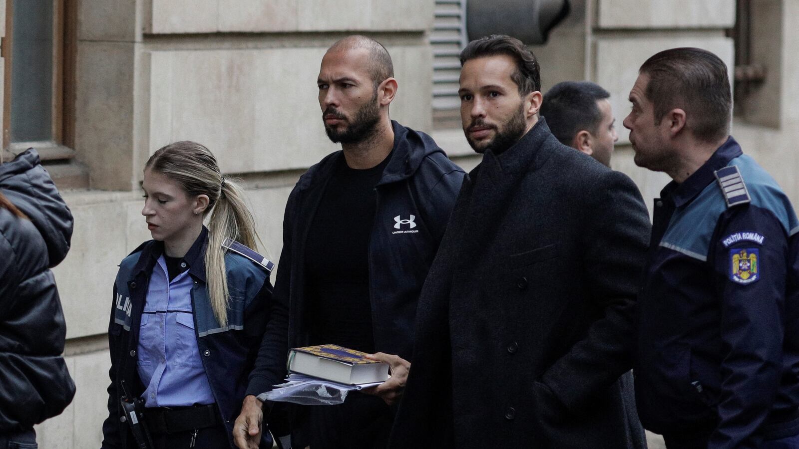 Andrew Tate and his brother Tristan are escorted by police officers outside the headquarters of the Bucharest Court of Appeal, in Bucharest, Romania, January 10, 2023.