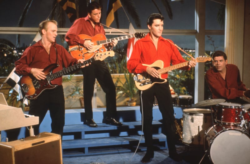 Elvis Presley playing guitar with band in scene from 'Girl Happy' 1965.