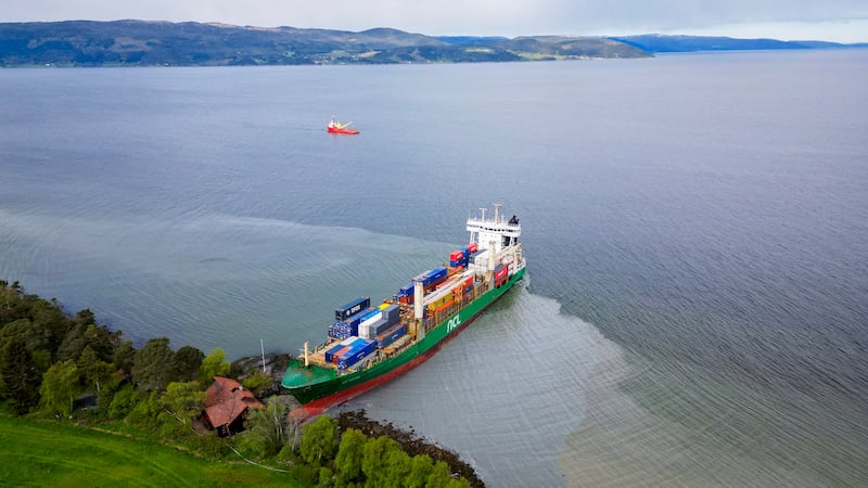 TOPSHOT - An areal view shows a 135-meter-long container ship by the shore in the Trondheimsfjord outside Byneset by Trondheim, Norway, on May 22, 2025, after it ran aground almost hitting a house. (Photo by Jan Langhaug / NTB / AFP) / Norway OUT (Photo by JAN LANGHAUG/NTB/AFP via Getty Images)