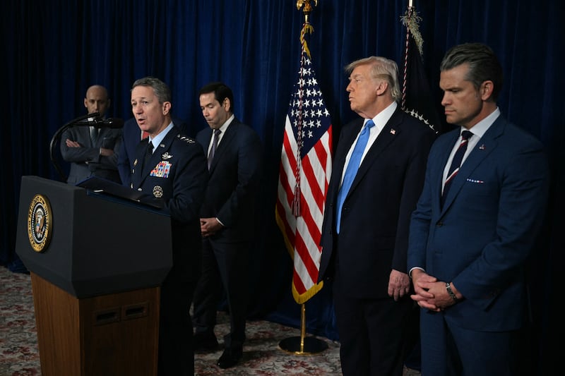 President Donald Trump stands by as Chairman of the Joint Chiefs of Staff General Dan Caine speaks to the press following US military actions in Venezuela, at Trump's Mar-a-Lago residence in Palm Beach, Florida, on January 3, 2026.