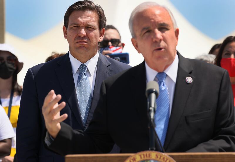 MIAMI, FLORIDA - APRIL 08: Florida Gov. Ron DeSantis listens as Rep. Carlos A. Gimenez (R-FL) speaks during a press conference  about the cruise industry at PortMiami on April 08, 2021 in Miami, Florida. The Governor announced that the state is suing the federal government to allow cruises to resume in Florida. (Photo by Joe Raedle/Getty Images)