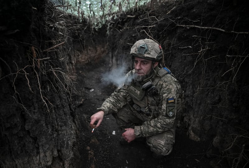 An artilleryman of the 44th Separate Artillery Brigade, named after Hetman Danylo Apostol, of the Armed Forces of Ukraine, smokes in a trench before a firing towards Russian troops, amid Russia's attack on Ukraine, in Dnipropetrovsk region, Ukraine December 24, 2025. REUTERS/Stringer
