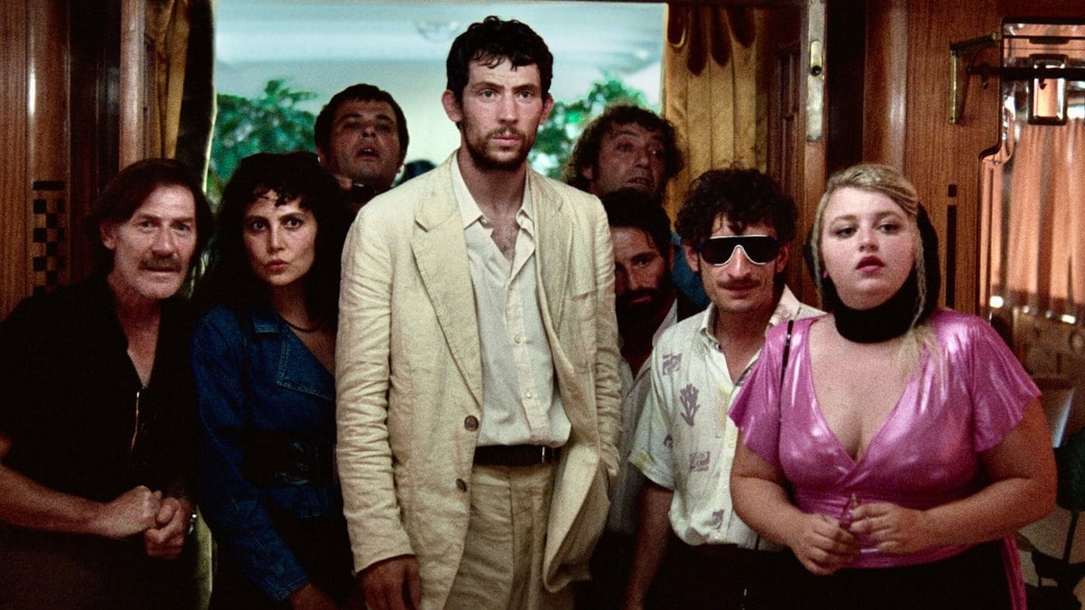 Josh O’Connor and the cast of ‘La Chimera’ stand together in a still from the movie.