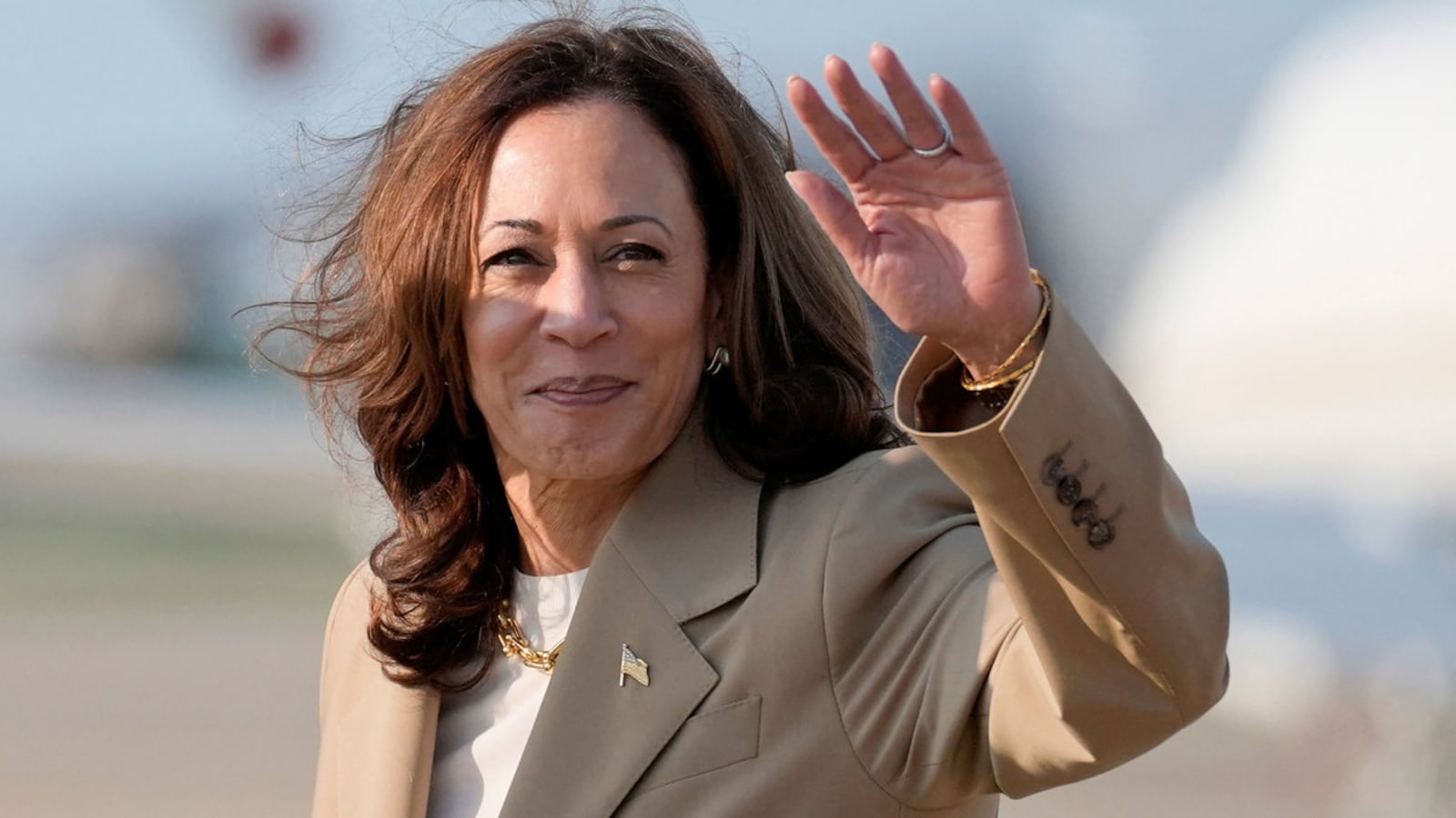 Kamala Harris waves to the crowd from the tarmac.