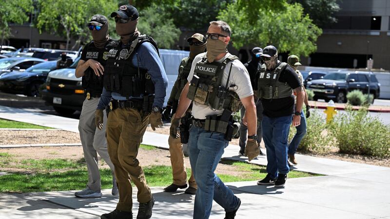 Masked law enforcement officers, including HSI and ICE agents, walk into an immigration court in Phoenix, Arizona, U.S., May 21, 2025.