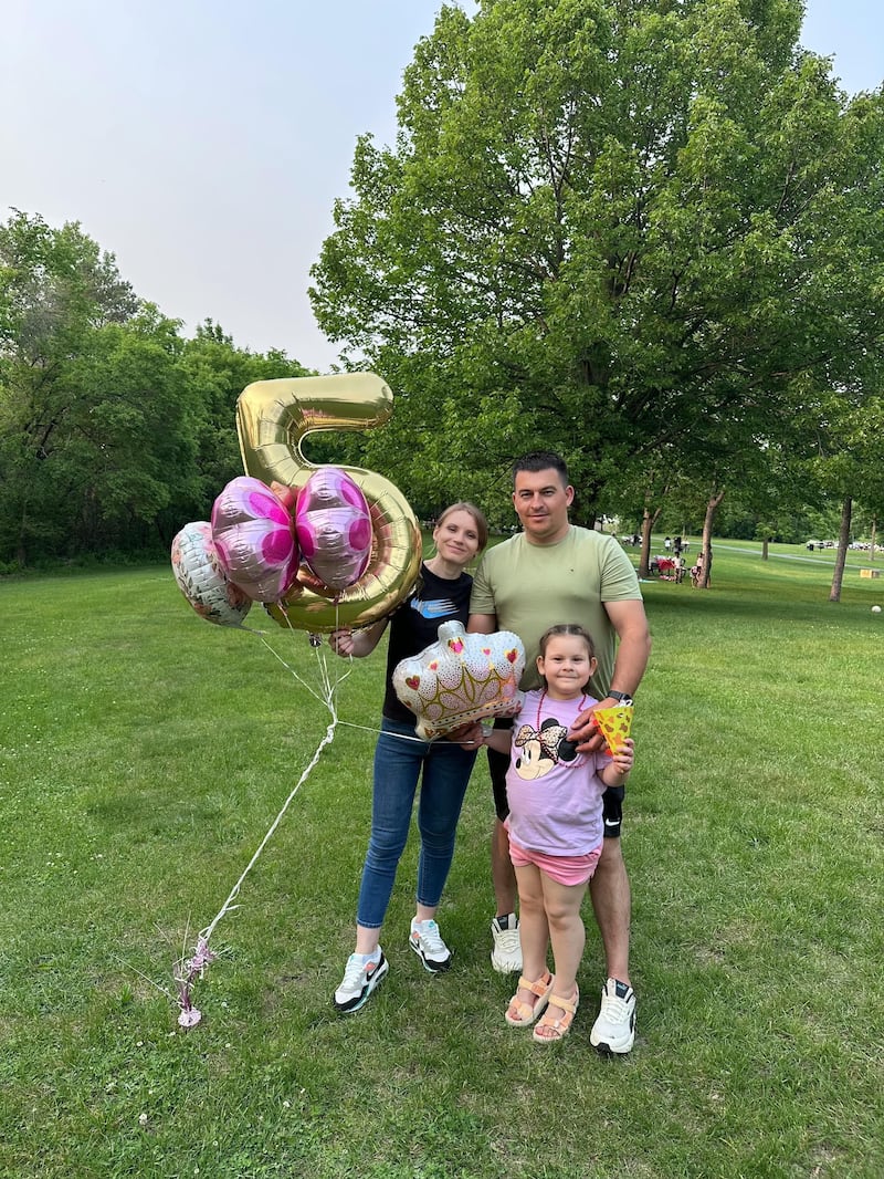 Dmytro Kulik poses with his wife Oksana and daughter Elina.