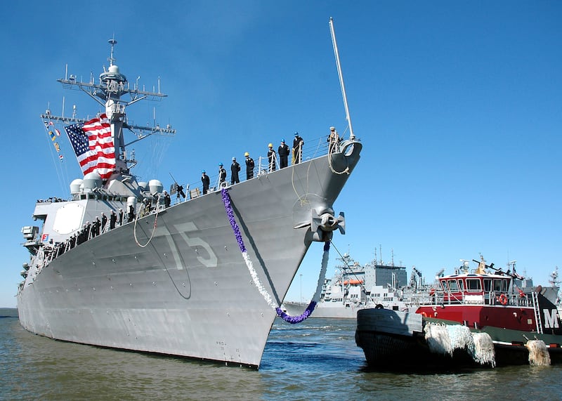 A tug boat guides the guided-missile destroyer USS Donald Cook to the pier as the ship returns to Naval Station Norfolk following a seven-month deployment. Donald Cook deployed to the U.S. 6th Fleet area of responsibility supporting theater security cooperation by participating in regional exercises with allies.