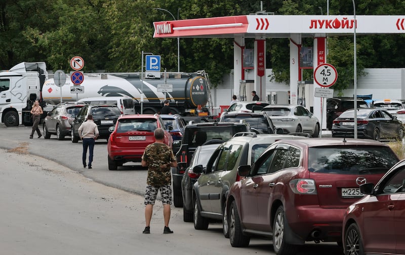 Cars line up to refuel at a Lukoil fuel station.