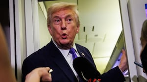 IN FLIGHT - FEBRUARY 06: U.S. President Donald Trump reacts after a reporter tells him that U.S. Vice President J.D. Vance was booed during the Opening Ceremony of the 2026 Winter Olympics during a gaggle with reporters while aboard Air Force One on February 6, 2026 en route to Palm Beach, Florida. The President is spending the weekend at Mar-a-Lago, his private club. (Photo by Samuel Corum/Getty Images)
