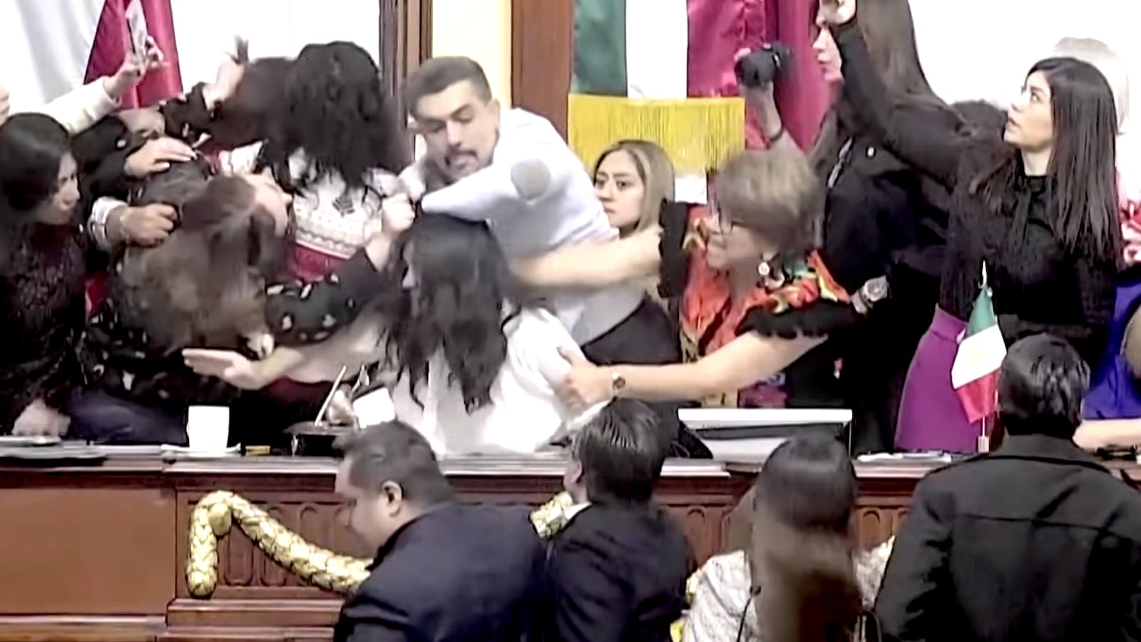 Mexican lawmakers were filmed shoving each other an pulling hair on the floor of Congress in Mexico City on Monday.
