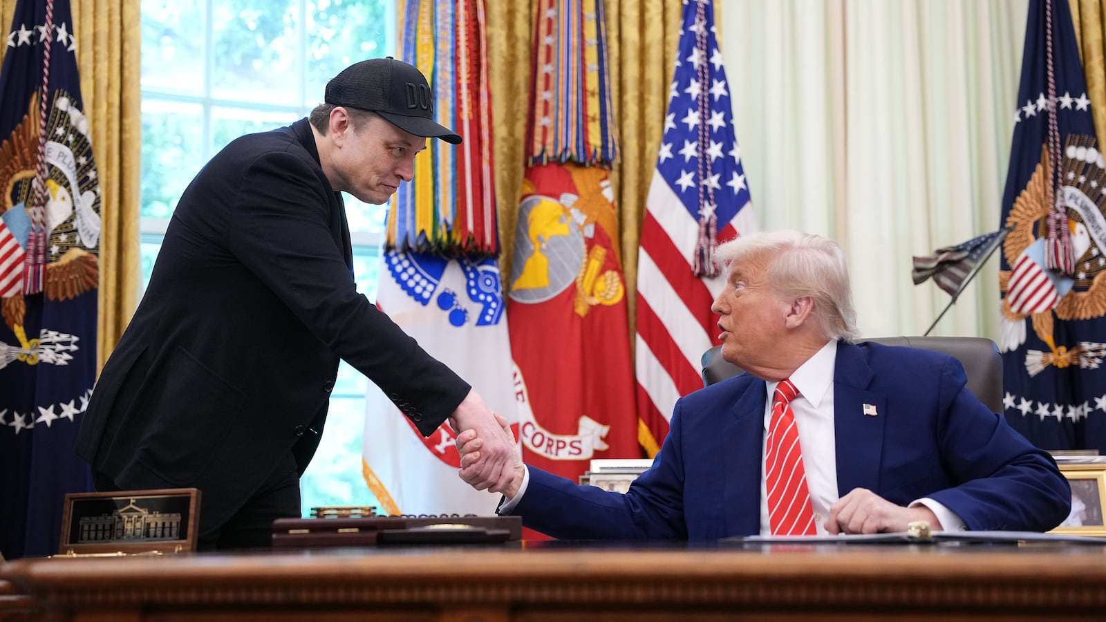 Elon Musk (left) shakes hands with President Donald Trump as they speak to reporters in the Oval Office of the White House on May 30, 2025 in Washington, DC.